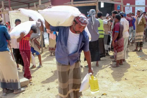Yerinden edilen Yemenliler, ülkenin kuzeybatısındaki Hacca’da Birleşmiş Milletler’den gıda yardımı alıyor (AFP)