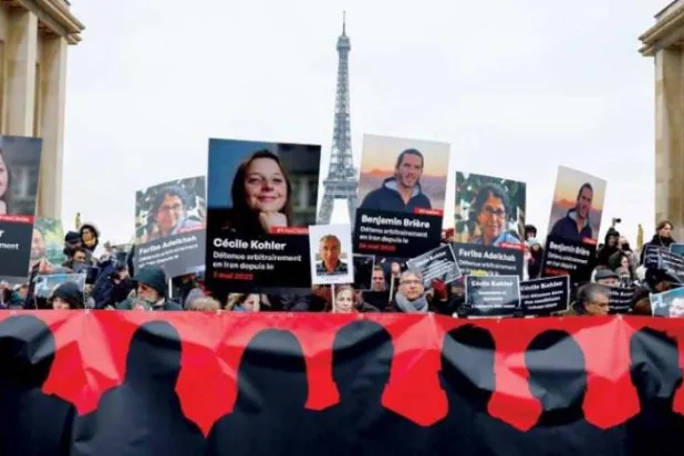 Demonstrators hold pictures of French detainees in Iran during a protest in Paris (Reuters)