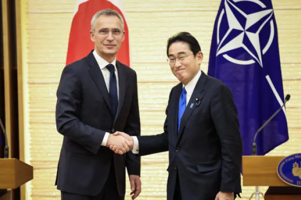 رئيس الوزراء الياباني (يمين) والأمين العام للناتو في مصافحة بعد انتهاء مؤتمرهما الصحافي المشترك اليوم بطوكيو (أ.ف.ب)