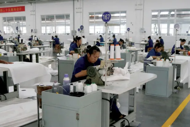 عاملات في مصنع ملابس شمال الصين (رويترز)