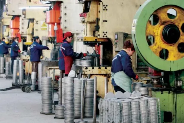 عمال في مصنع منتجات ألمنيوم بمقاطعة آنهوي بشرق الصين (أ.ف.ب)