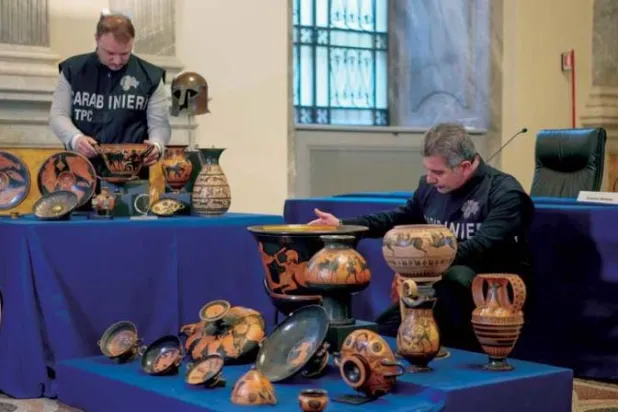 شرطيا الكارابينيري يعرضان 60 قطعة أثرية مسروقة (أ.ب)