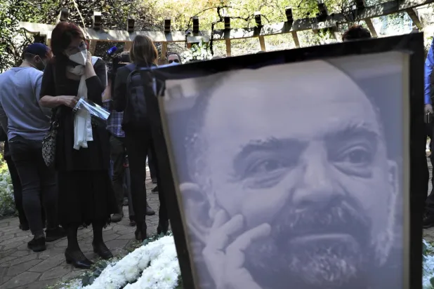 A mourner, left, looks at a monument of Lokman Slim during a memorial service to pay tribute to the slain Lebanese political activist in the southern suburb of Beirut, Lebanon, Thursday, Feb. 11, 2021. (AP)
