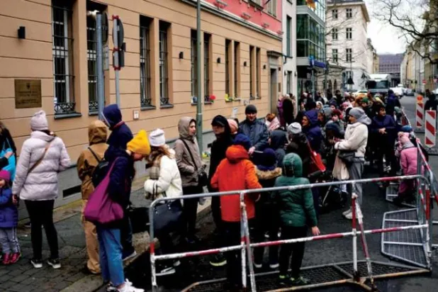 لاجئون أوكرانيون أمام قنصلية بلادهم في برلين (أ.ب)