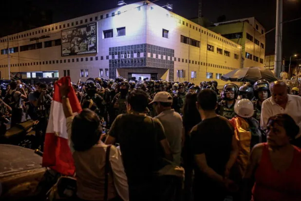 متظاهرون أمام مركز شرطة في ليما (إ.ب.أ)