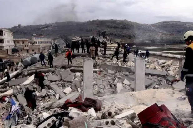 فرق الدفاع المدني السوري تعمل على إنقاذ الضحايا في تجمع سكني مدمر بالزلزال في مدينة سرمدا شمال إدلب (الشرق الأوسط)