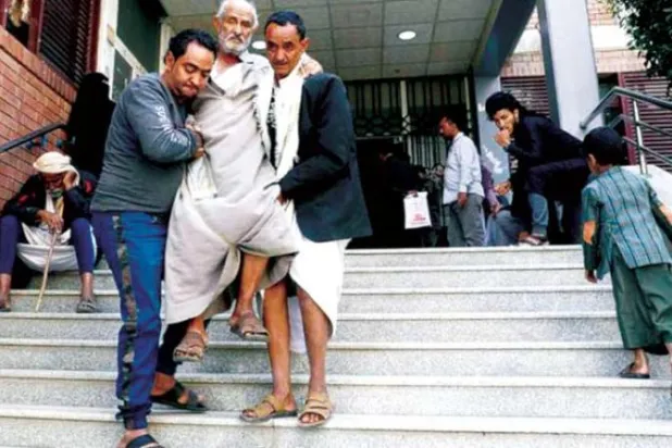 مرضى بالسرطان ومراجعون أمام بوابة أحد المستشفيات في صنعاء (رويترز)