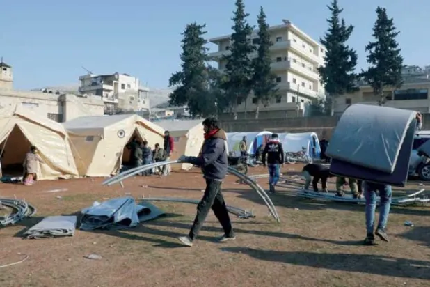 من أعمال تحضير مخيم للمتضررين في حارم (رويترز)