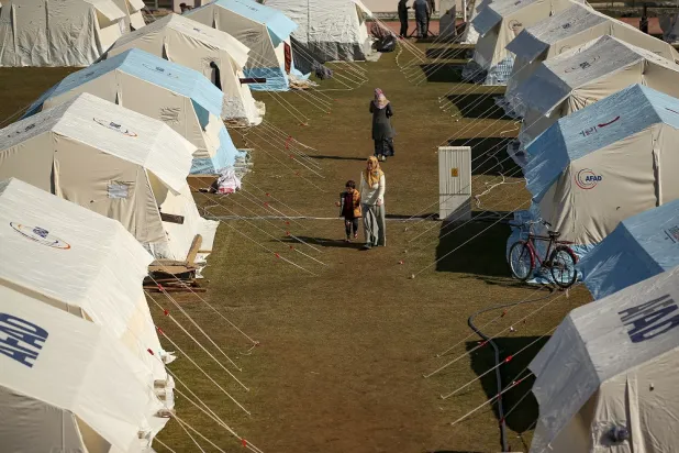 People walk in a tented camp set up for survivors in Adiyaman, southern Türkiye, Monday, Feb. 13, 2023. (AP)
