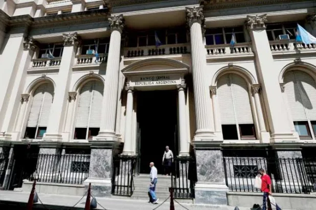 مشاة أمام مقر البنك المركزي الأرجنتيني في العاصمة بوينس آيرس (رويترز)