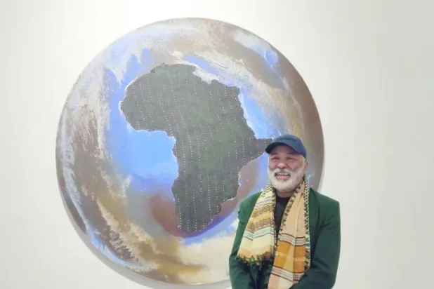 محمد المرابطي الفنان التشكيلي المغربي أمام لوحة من لوحاته (الشرق الأوسط)