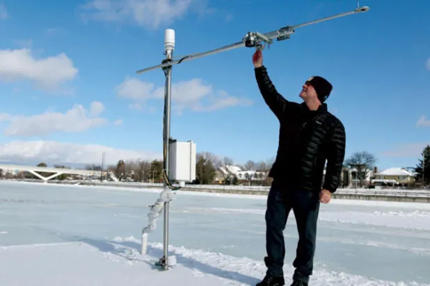 شون كيني أستاذ الهندسة والبيئة بجامعة كارلتون يقوم بتعديلات على محطة الطقس في المدرج (أ.ف.ب)