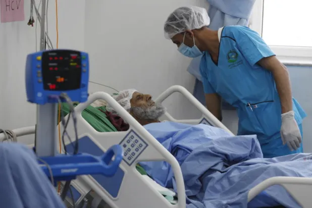 طبيب يمني يعاين مريضاً في أحد مستشفيات صنعاء (إ.ب.أ)