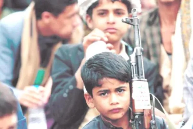 طفل يمني يحمل سلاحاً خلال تجمع للحوثيين في العاصمة صنعاء (غيتي)