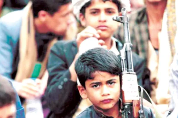 طفل يمني يحمل سلاحاً خلال تجمع للحوثيين في العاصمة صنعاء (غيتي)