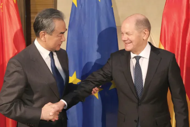 وزير الخارجية الصيني مع المستشار الألماني في ميونيخ أمس (إ.ب.أ)