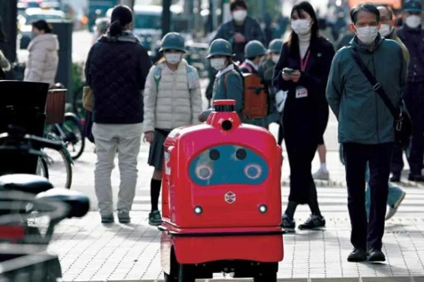 روبوت للتوزيع يسير في أحد شوارع طوكيو 13 يناير الماضي (أ.ف.ب)