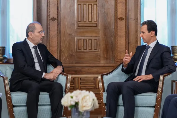 15 February 2023, Syria, Damascus: A photo released by the official Syrian Arab news agency (SANA) on 15 February shows Syrian President Bashar al-Assad (R) speaking with Jordanian Foreign Minister Ayman al-Safadi. (SANA/dpa)