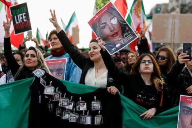 زنان در تظاهراتی در پاریس، ۱۱ فوریه ۲۰۲۳، تصاویر قربانیان سرکوب در اعتراضات ایران را در دست دارند (AFP)