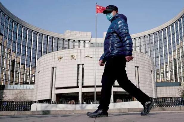 رجل يسير أمام مقر بنك الشعب الصيني في بكين (رويترز)