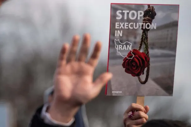 متظاهرون يرفعون أيديهم خلال وقفة للتنديد بالحكومة الإيرانية في واشنطن (أ.ف.ب)