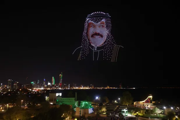 An image made out of drones in the effigy of Emir of Kuwait Nawaf Al-Ahmad Al-Jaber Al Sabah, hovers above the Green Island off the coast of Kuwait City on February 16, 2023, as the country celebrates throughout the month of February its 62nd Independence Day and the 32nd anniversary of the end of the Gulf war with the liberation of Kuwait. (AFP)