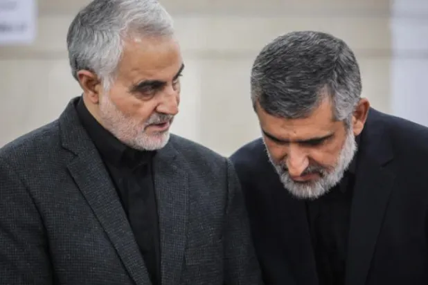 Amirali Hajizadeh listens to whispers from Qassem Soleimani on the sidelines of a ceremony in 2018 (File– Mehr News Agency)
