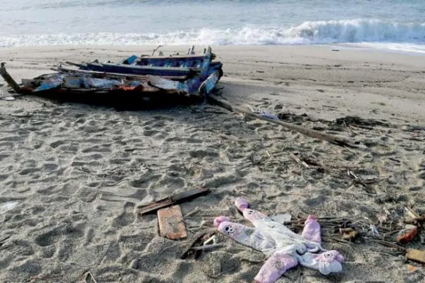 ثوب طفل وقطع خشب جرفتها الأمواج أمس بعد يومين من غرق سفينة مهاجرين بمنطقة كالابريا (أ.ف.ب)