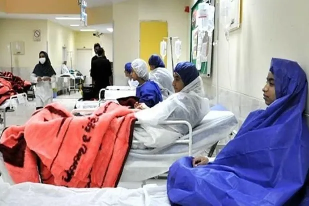 فتيات أُصبن بحالة تسمم في مدرسة في أثناء تلقي العلاج في مستشفى بمدينة قم الإيرانية الشهر الماضي (تسنيم)