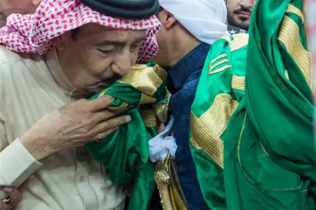 King Salman bin Abdulaziz kissing the Saudi flag (Asharq Al-Awsat)