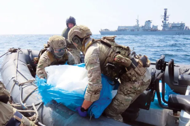 جنديان يحملان بعضاً من شحنة الأسلحة الإيرانية المصادرة في خليج عمان (البحرية البريطانية)