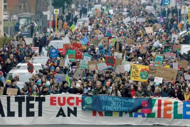 مظاهرة وسط برلين لدعم حماية المناخ وتبدو لافتة موجهة للحكومة كتب عليها «التزموا الأهداف» (أ.ف.ب)
