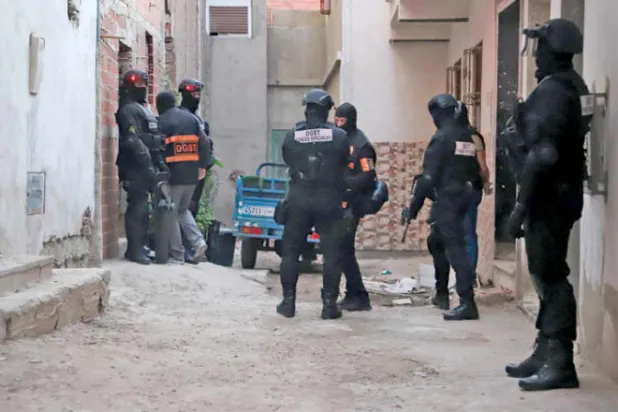 مجموعة من عناصر الأمن ومكافحة الإرهاب يقفون أمام منزل في مدينة طنجة 6 أكتوبر 2021 (أ.ف.ب)