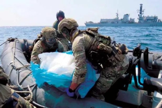 İki asker Perşembe günü Umman Körfezi'nde ele geçirilen İran silahlarını taşırken (ABD Donanması)