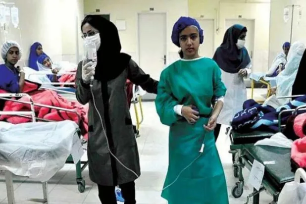 تہران کے ایک ہسپتال میں علاج کے دوران ایک استاد طالبہ کی مدد کرتے ہوئے (برنا)

