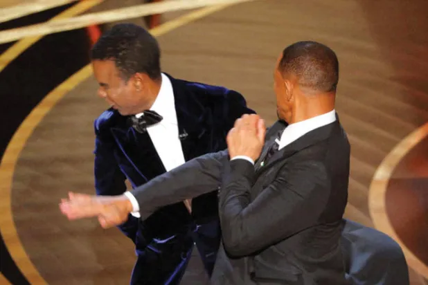 ويل سميث يضرب كريس روك خلال حفل الأوسكار (رويترز)