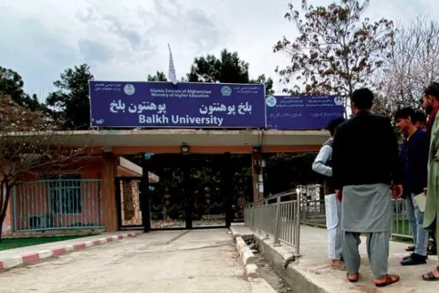 شبان أمام مدخل جامعة بلخ بعدما أعيد فتح أبواب الجامعات في مزار الشريف أمس (أ.ف.ب)