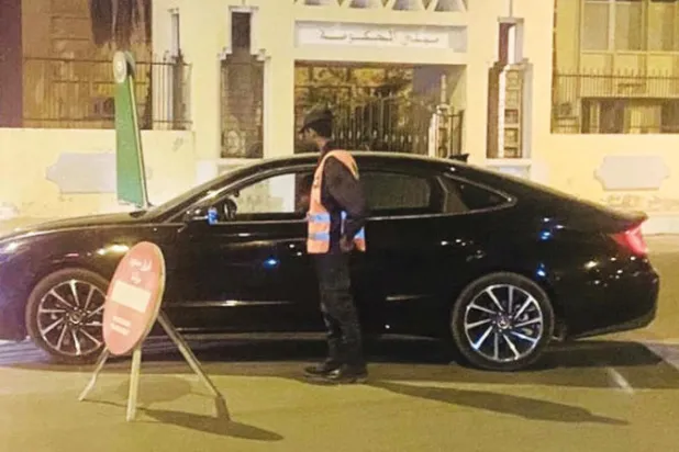 عنصر من الأمن الموريتاني يفتش سيارة قبالة مبنى حكومي بعد ساعة من فرار سجناء «القاعدة» (الشرق الأوسط)