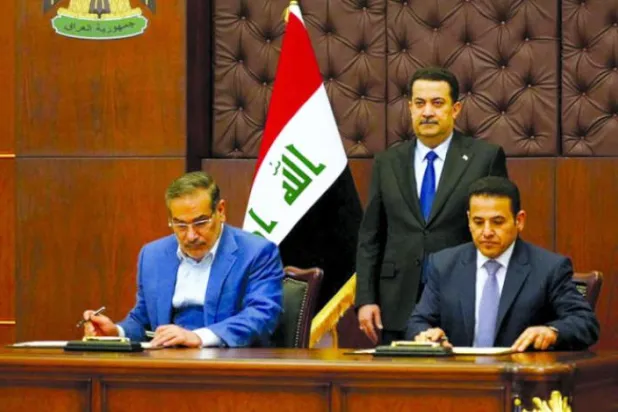 شمخانی اور الاعرجی کل بغداد میں السودانی کی موجودگی میں معاہدے کی دستاویزات پر دستخط کرتے ہوئے (رائٹرز)