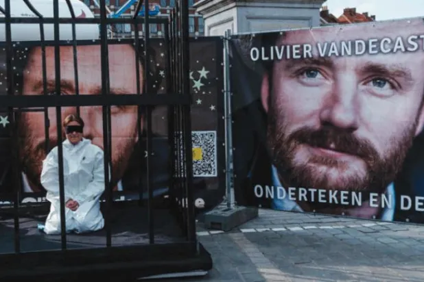 ایران میں گرفتار کیے گیے بیلجیئم کے انسانی ہمدردی کے کارکن اولیور وینڈیکاسٹل کے پوسٹر کے سامنے ایک لوہے کے پنجرے کے اندر ایک خاتون برسلز میں گزشتہ ہفتے مظاہرہ کر رہی ہے (اے ایف پی)