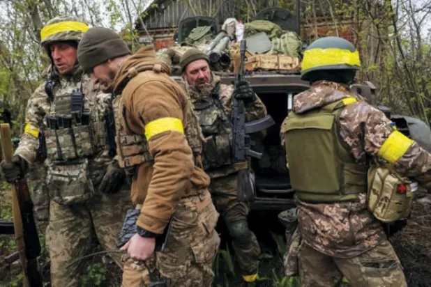 یوکرینی فوجی کل ملک کے مشرق میں ڈونیٹسک میں فرنٹ لائن کے قریب پیادہ لڑنے والی گاڑی کے سامنے کھڑے ہیں (رائٹرز)