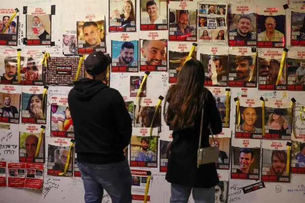 Tel Aviv duvarlarında, 7 Ekim saldırısından bu yana Gazze'de tutulan İsrailli rehinelerin resimleri asılı. (AFP)