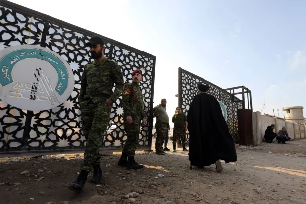 رجل دين في طريقه إلى مقر الحشد الشعبي الذي شهد هجوماً بأربعة صواريخ أميركية اليوم الخميس (أ.ف.ب)