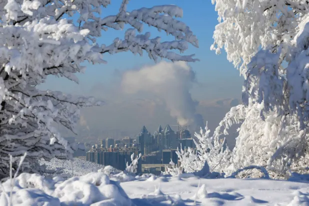 ارتفاع غاز المداخن والبخار من المداخن بعد أن غطت الثلوج مدينة ألماتي في كازاخستان وانخفضت درجة حرارة الهواء إلى 20 درجة مئوية تحت الصفر (رويترز)