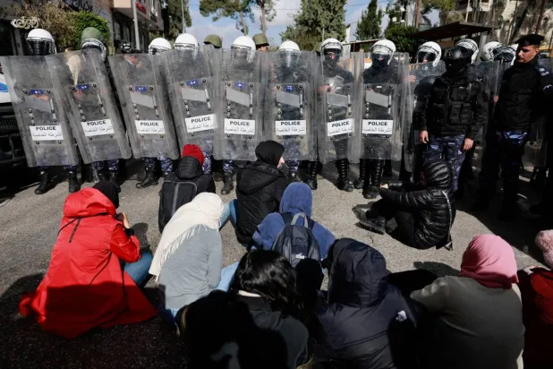 Riot police in front of demonstrators in Ramallah protesting the visit of US Secretary of State Antony Blinken on Wednesday (Reuters)
