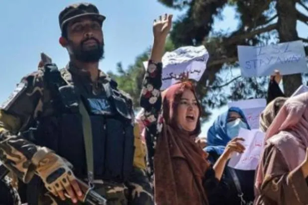 أفغانيات يتظاهرن في كابل ويقف إلى جانبهن مقاتل من «طالبان» (أ.ف.ب)