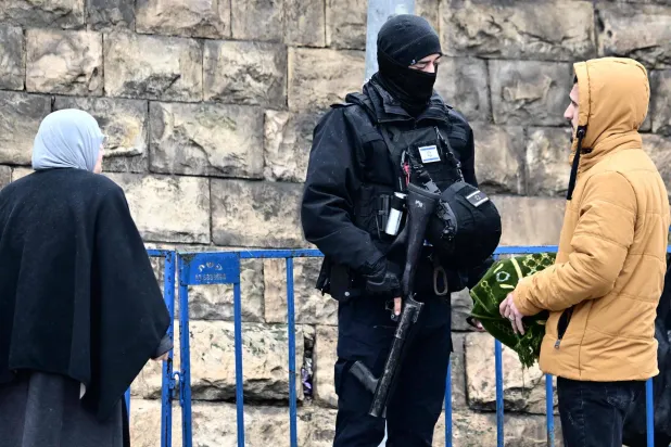 شرطي إسرائيلي يوقف مصلين في القدس الجمعة (أ.ف.ب)