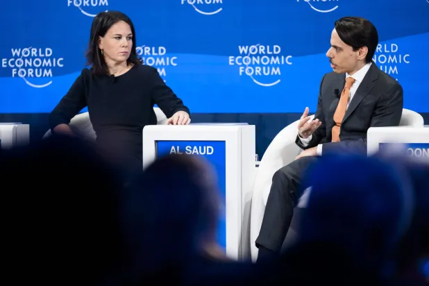 وزيرة خارجية ألمانيا مصغية إلى كلام بن فرحان في «دافوس» (إ.ب.أ)