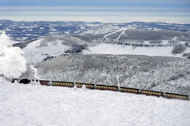 قطار يعبر منطقة مغطاة بالثلوج في طريقه إلى جبل بشمال ألمانيا (أ.ب)