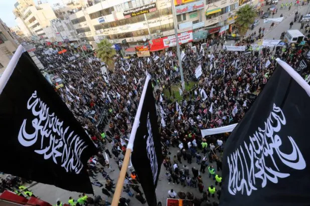 مناصرون لـ«حزب التحرير الإسلامي» يحملون أعلامه خلال وقفة احتجاجية في فلسطين (المكتب الإعلامي للحزب)